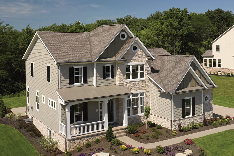 Two-story house with brown roof and porch.