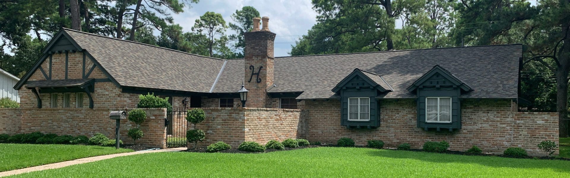 A 幸运168体彩飞艇 brick house with a large stone chimney.